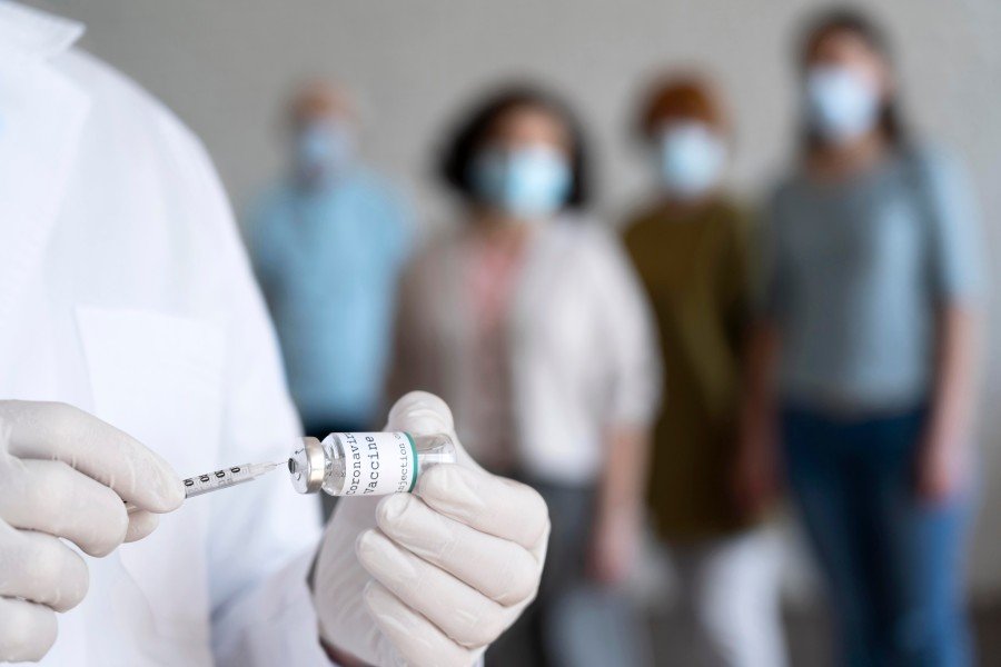 Healthcare professional preparing a vaccine injection with a syringe