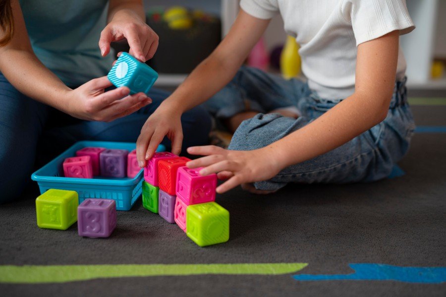Child engaging in a developmental activity with colorful building blocks