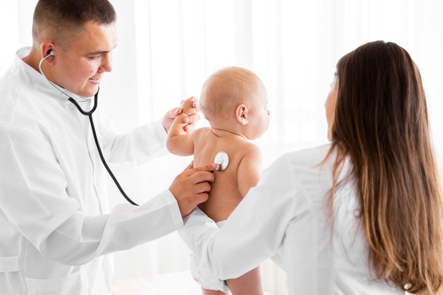 Pediatrician examining a newborn baby during a routine health checkup